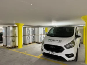 Lieferwagen von VESHKO Haushaltapparate in Tiefgarage mit neuen Waschmaschinen auf Paletten – Lieferung und Service im Aargau und Zürich.